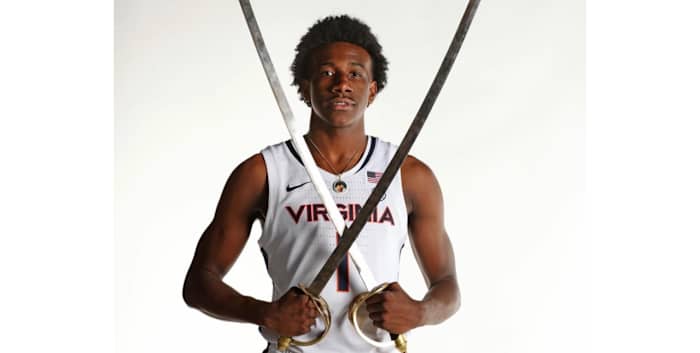 Four-star shooting guard Davin Cosby poses with two sabers in a UVA uniform during his official visit to the Virginia men's basketball program.
